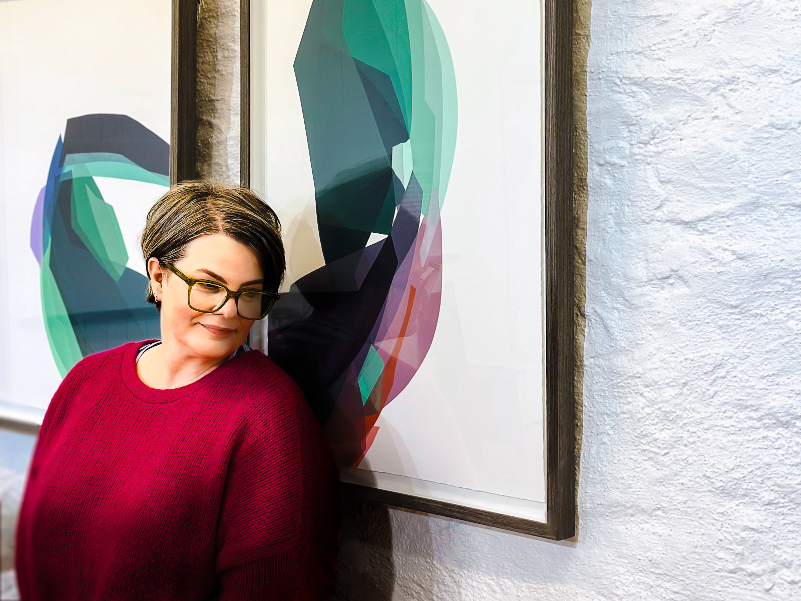 Artist Kellie Fergusson standing infront of her artwork, two framed unique state block prints.