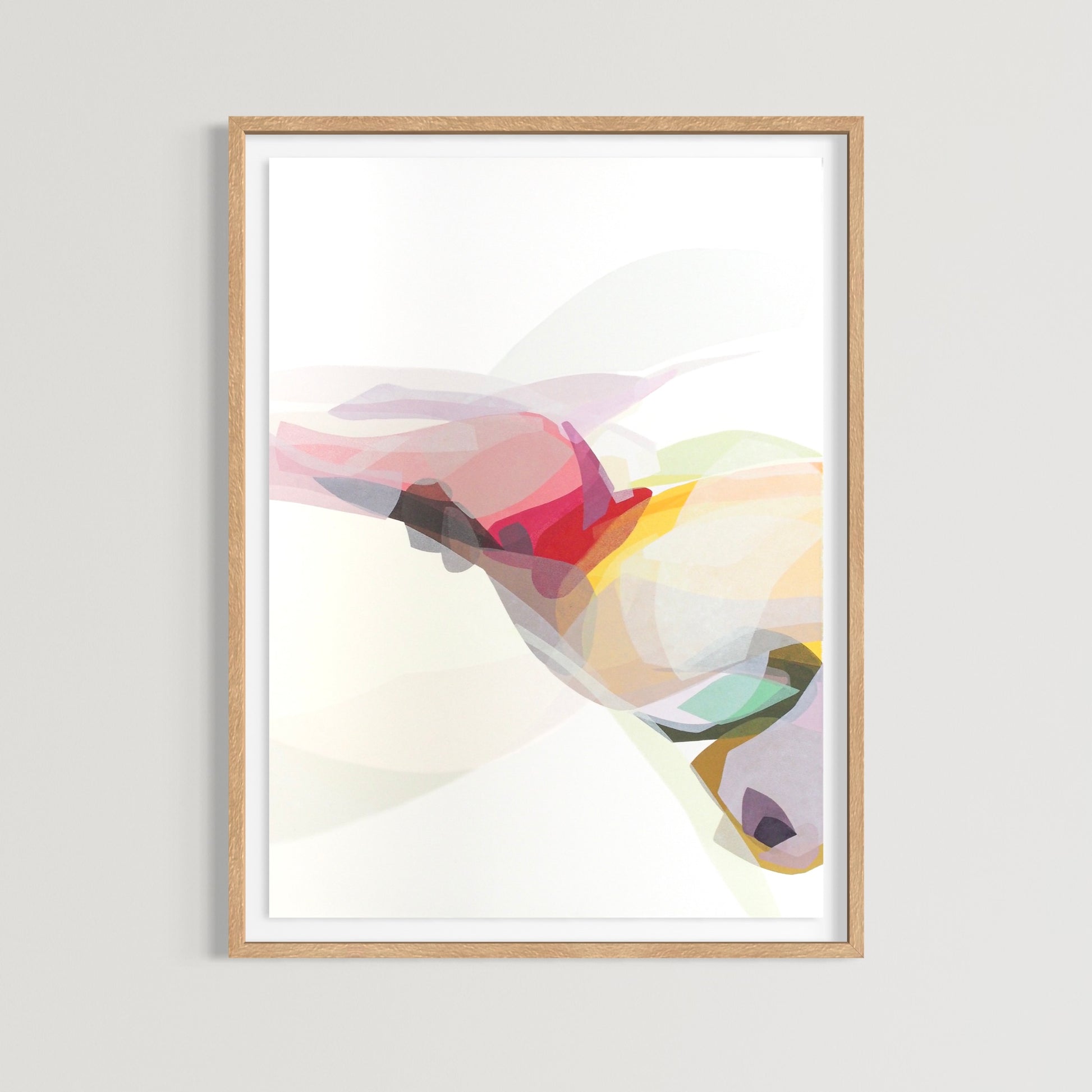 Framed abstract art print with colorful layered shapes hung 
on a white wall